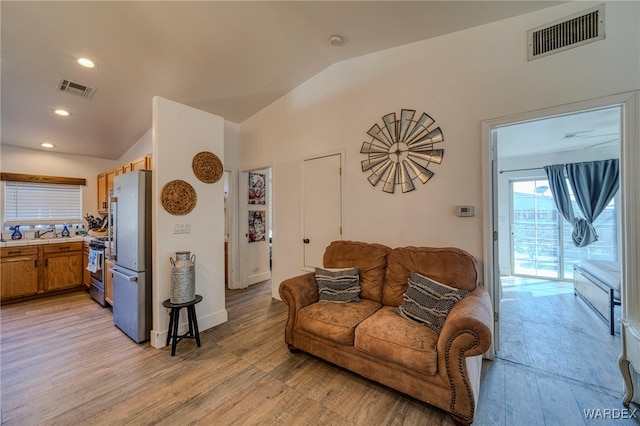 living area with lofted ceiling, light wood-style flooring, visible vents, and recessed lighting