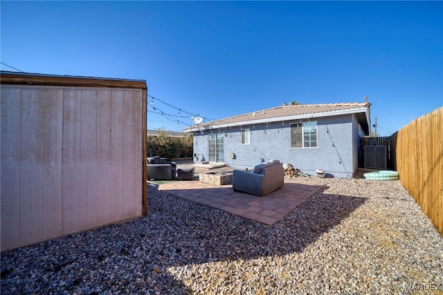 rear view of property featuring a patio, an outdoor fire pit, a fenced backyard, a tile roof, and stucco siding