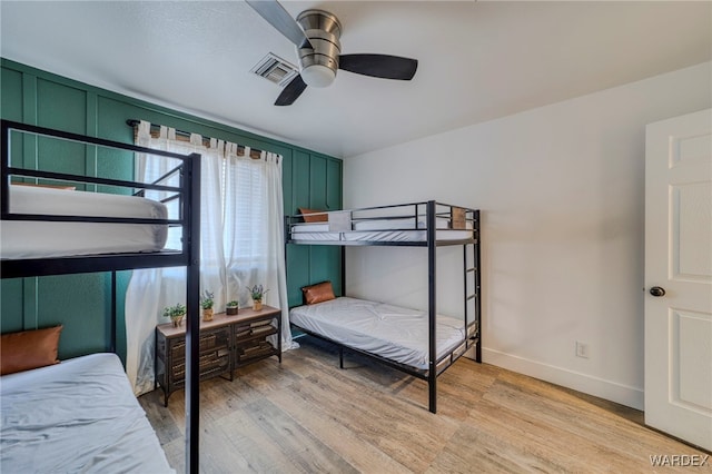 bedroom with light wood-type flooring, baseboards, visible vents, and a ceiling fan