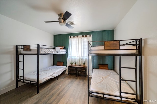 bedroom with baseboards, visible vents, and wood finished floors