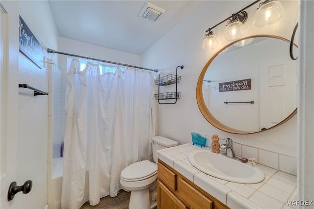 bathroom with toilet, shower / tub combo, visible vents, and vanity