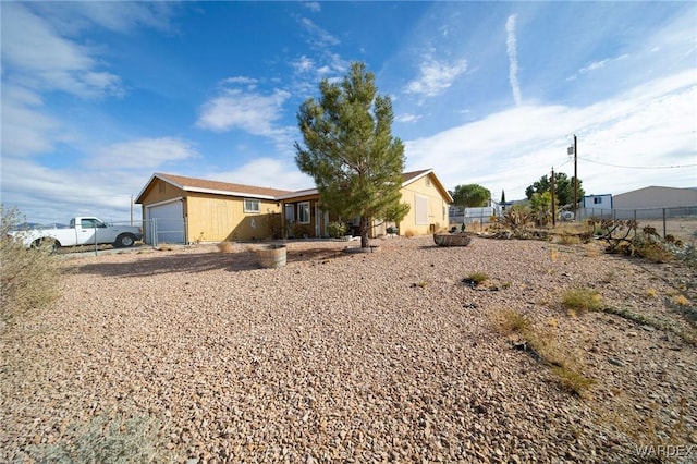 view of front of home with a garage and fence