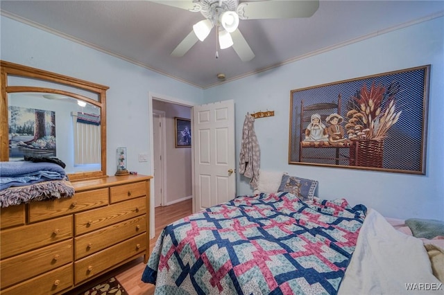 bedroom featuring a ceiling fan, crown molding, and wood finished floors