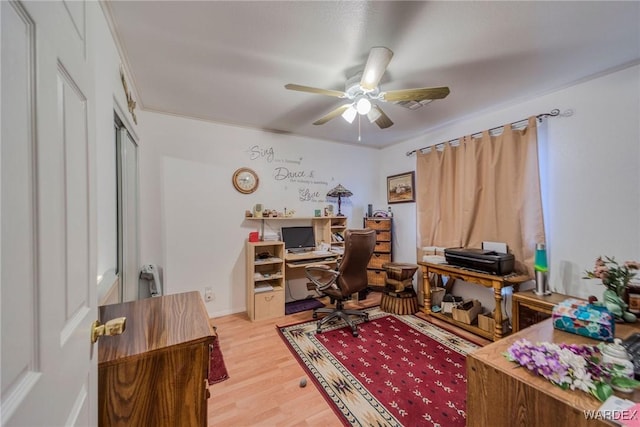 home office featuring a ceiling fan, baseboards, ornamental molding, and light wood finished floors