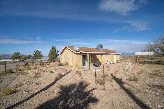 back of property with fence and stucco siding