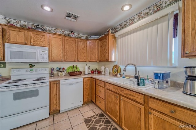 kitchen featuring light tile patterned flooring, white appliances, a sink, light countertops, and brown cabinets