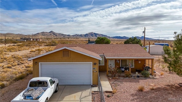 ranch-style home featuring concrete driveway, an attached garage, a mountain view, a porch, and stucco siding