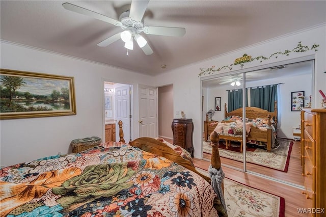 bedroom with ornamental molding, a closet, light wood-style flooring, and a ceiling fan