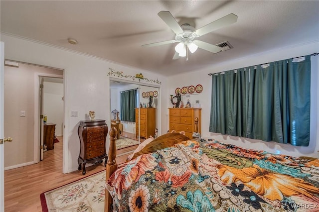 bedroom with light wood-type flooring, visible vents, ceiling fan, and baseboards