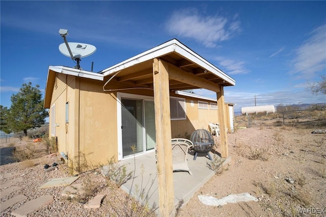 view of property exterior with a fire pit and a patio