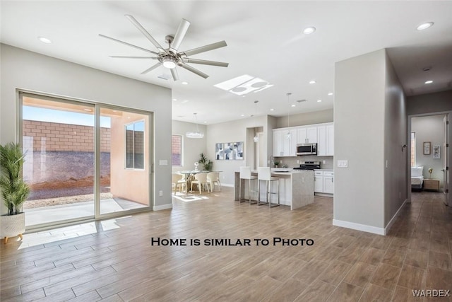 unfurnished living room featuring baseboards, wood finished floors, and recessed lighting