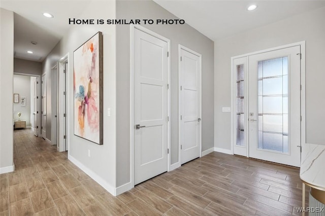 foyer with baseboards, a wealth of natural light, light wood-style flooring, and recessed lighting