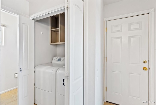 laundry room featuring laundry area, light tile patterned flooring, and washing machine and clothes dryer