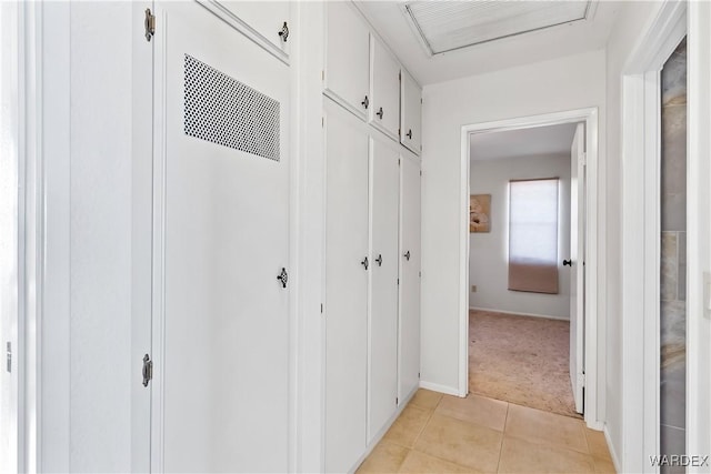 hall featuring light colored carpet, visible vents, and light tile patterned flooring