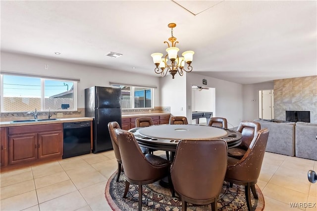 dining area featuring light tile patterned floors, visible vents, and an inviting chandelier