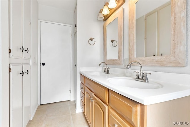 full bath with double vanity, tile patterned flooring, and a sink