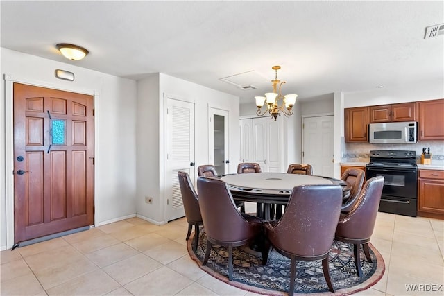 dining space featuring visible vents, a chandelier, baseboards, and light tile patterned flooring