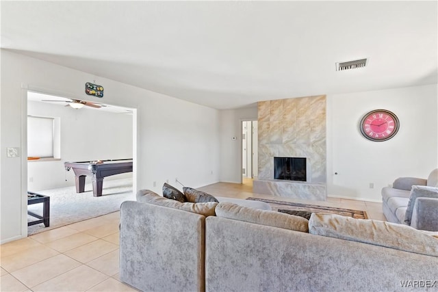 living room with light tile patterned floors, ceiling fan, a fireplace, billiards, and visible vents