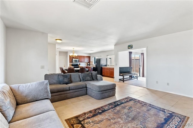 living room featuring baseboards, visible vents, a notable chandelier, and light tile patterned flooring