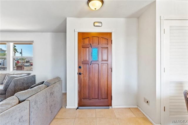 entryway with light tile patterned floors and baseboards