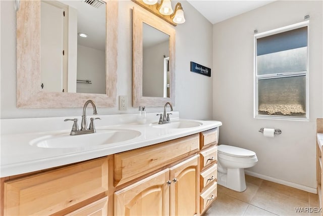 bathroom with double vanity, a sink, toilet, and tile patterned floors