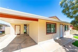 back of property with a carport and concrete driveway