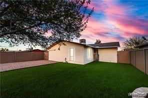 back of house featuring a patio, a fenced backyard, and a lawn