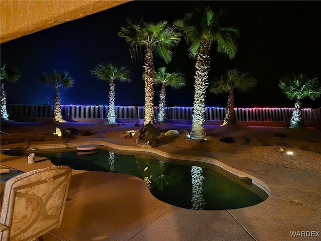 pool at twilight featuring a patio area, fence, and a fenced in pool