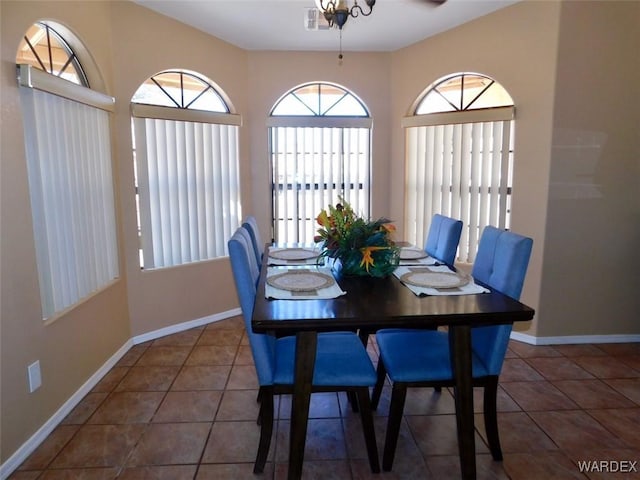 dining space featuring dark tile patterned floors, visible vents, and baseboards