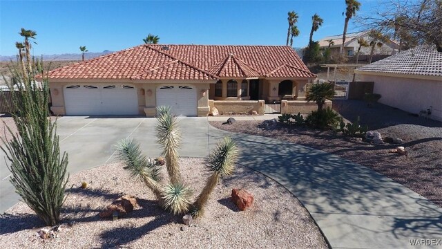 mediterranean / spanish home featuring a garage, a tile roof, concrete driveway, and stucco siding