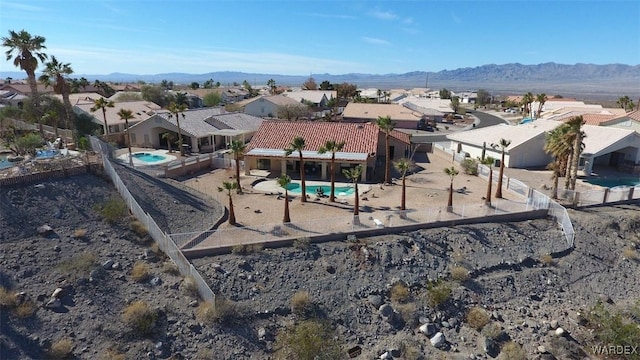 view of playground featuring a mountain view, fence, and a residential view