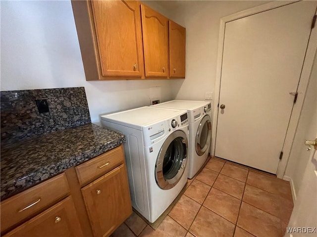 washroom with washer and dryer, cabinet space, and light tile patterned flooring