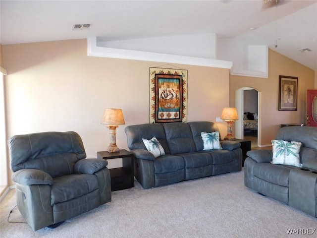 living room with lofted ceiling, visible vents, arched walkways, and light colored carpet