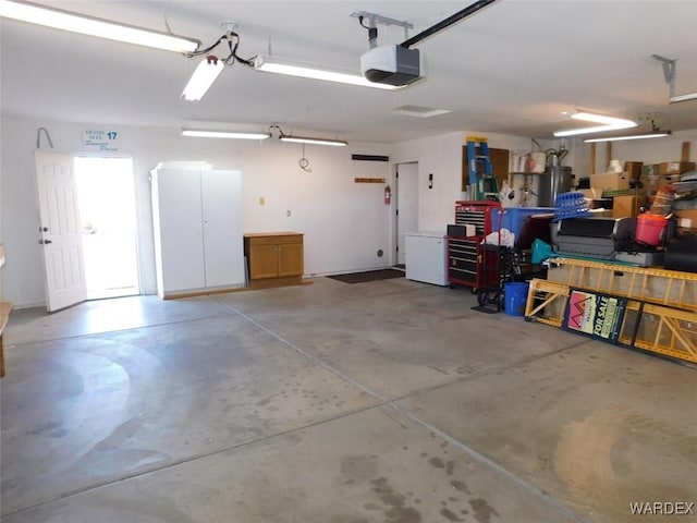 garage featuring a garage door opener and a workshop area