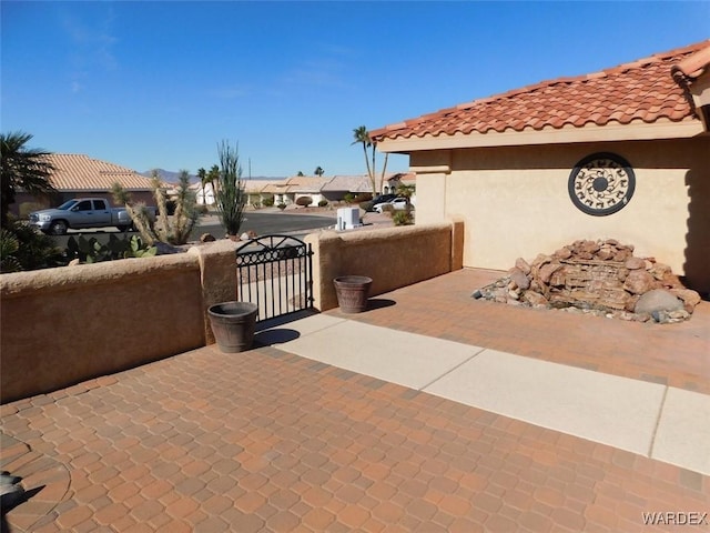 view of patio with a gate, fence, and a residential view