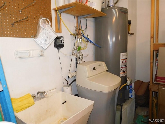 laundry room with laundry area, a sink, and gas water heater