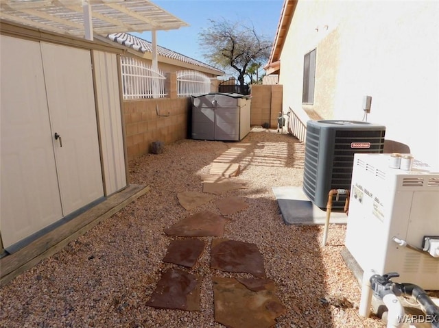 view of yard featuring central AC, fence, and a pergola