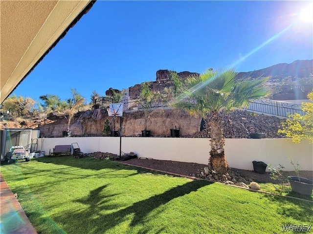 view of yard with a fenced backyard and a mountain view