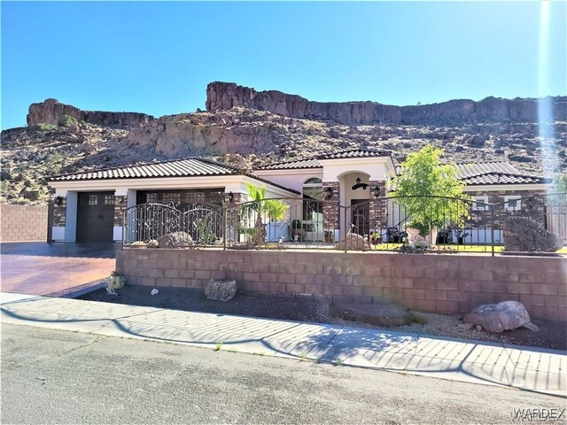 view of front of property featuring a garage, a fenced front yard, a gate, and a mountain view