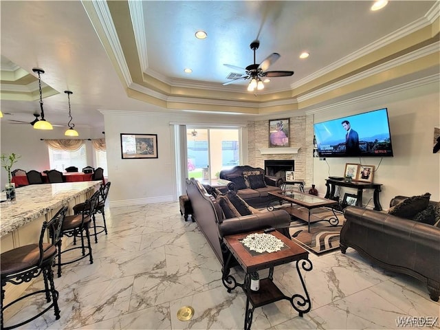 living room featuring plenty of natural light, a fireplace, and a raised ceiling