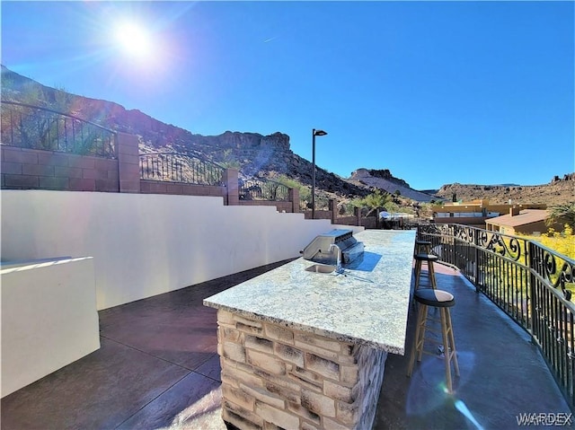view of patio featuring an outdoor bar, a mountain view, and an outdoor kitchen