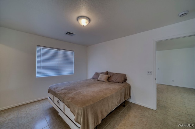 bedroom with visible vents, baseboards, and light tile patterned floors