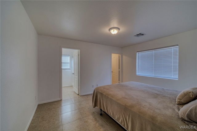 bedroom with visible vents, baseboards, and light tile patterned floors