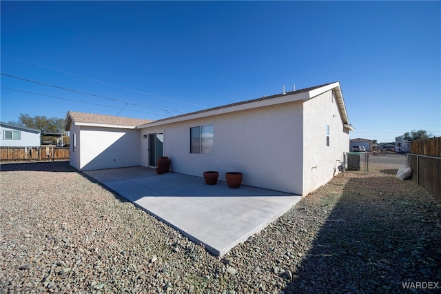 rear view of property with a patio area, a fenced backyard, and stucco siding