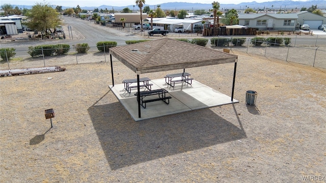 surrounding community featuring fence, a mountain view, and a patio