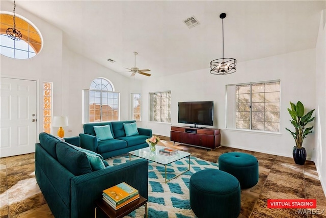 living area with high vaulted ceiling, baseboards, visible vents, and ceiling fan with notable chandelier