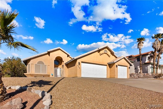 view of front facade featuring a garage, driveway, and stucco siding