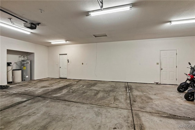 garage featuring a garage door opener and electric water heater