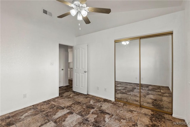 unfurnished bedroom with a closet, visible vents, stone finish flooring, ceiling fan, and baseboards