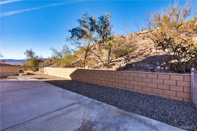 view of yard featuring a patio, a fenced backyard, and a mountain view